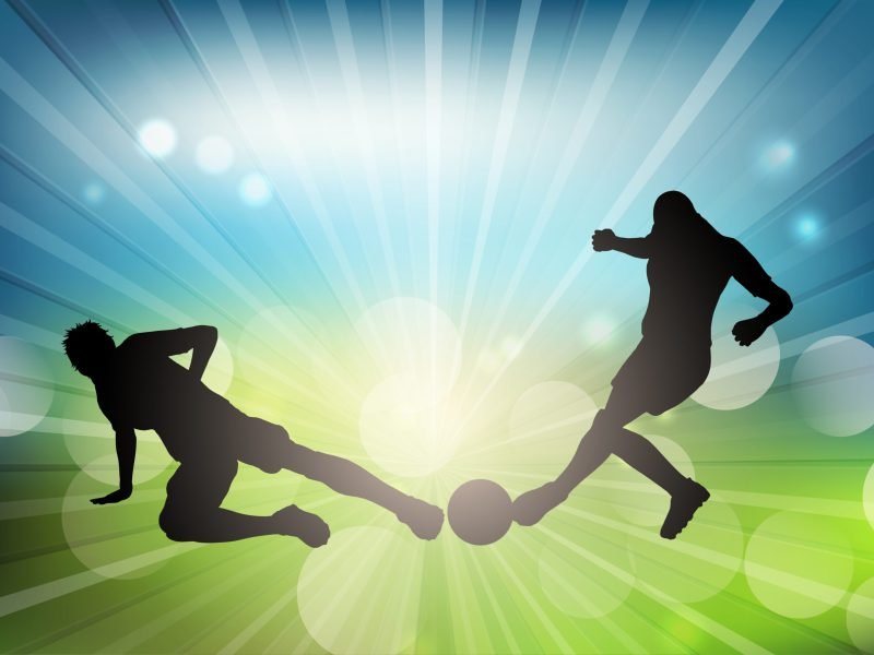 Soccer or football player silhouettes on a defocussed background